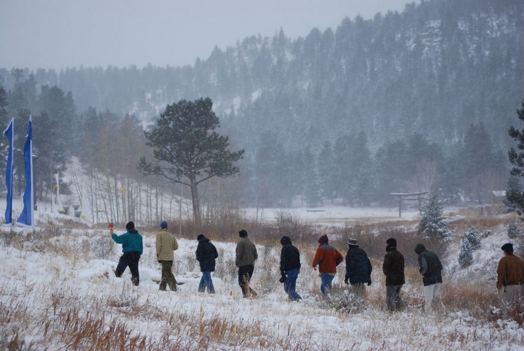 Group walks through snowy forest during winter